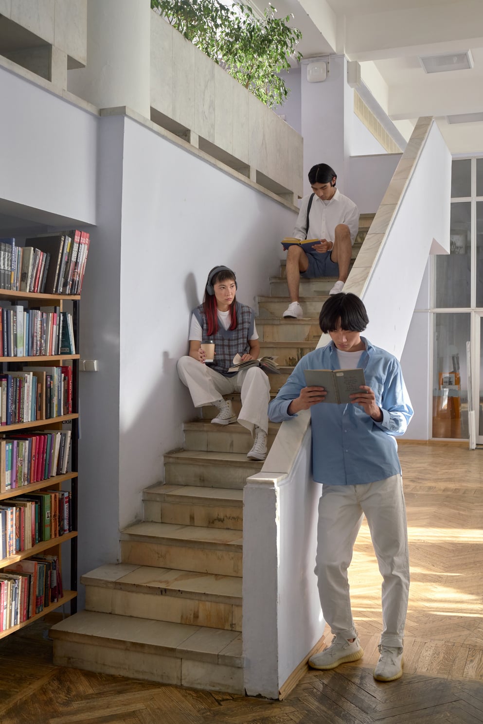 Students on a Staircase of a Library